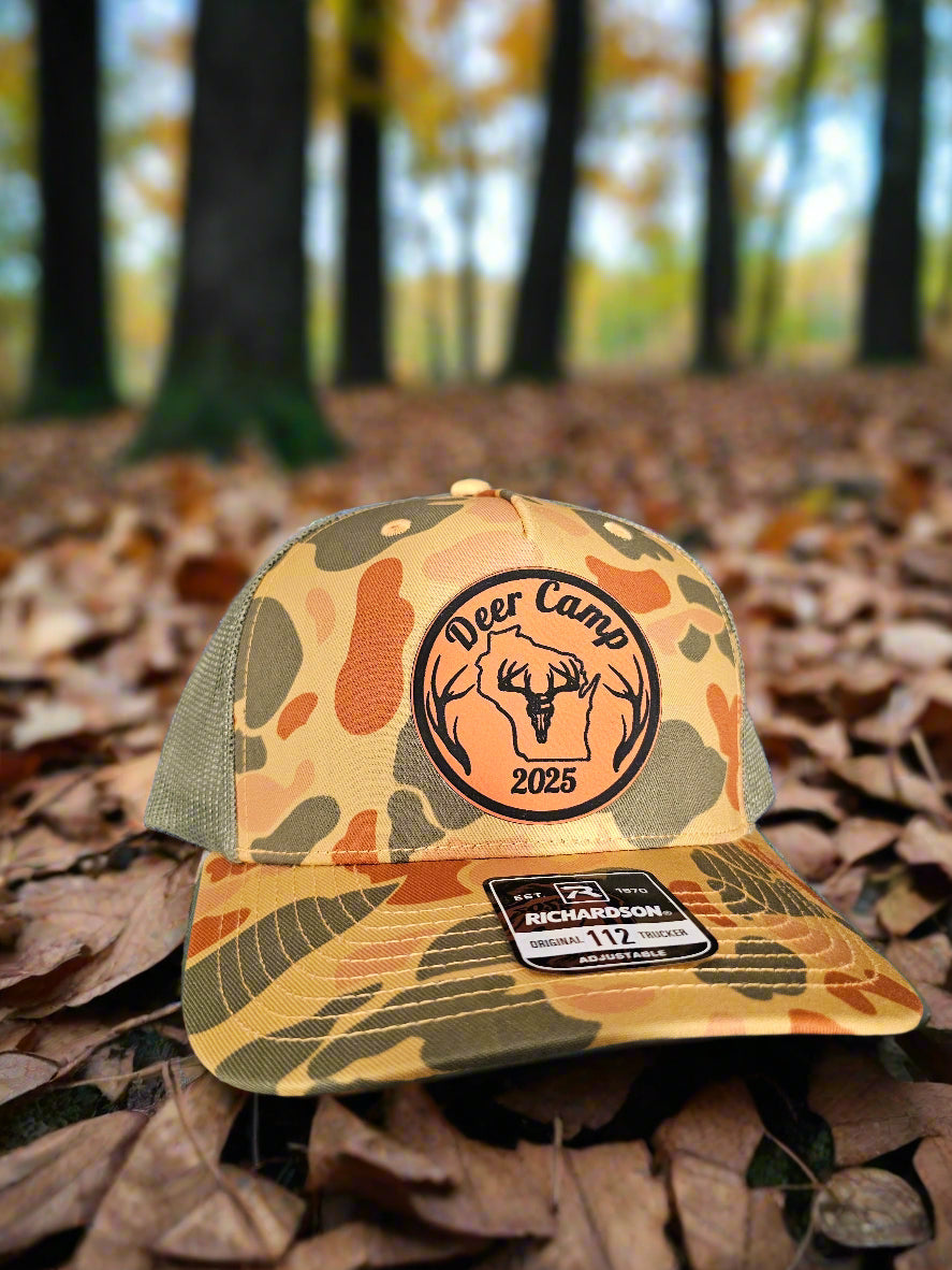 Camouflage-patterned cap with a logo and text on a textured surface