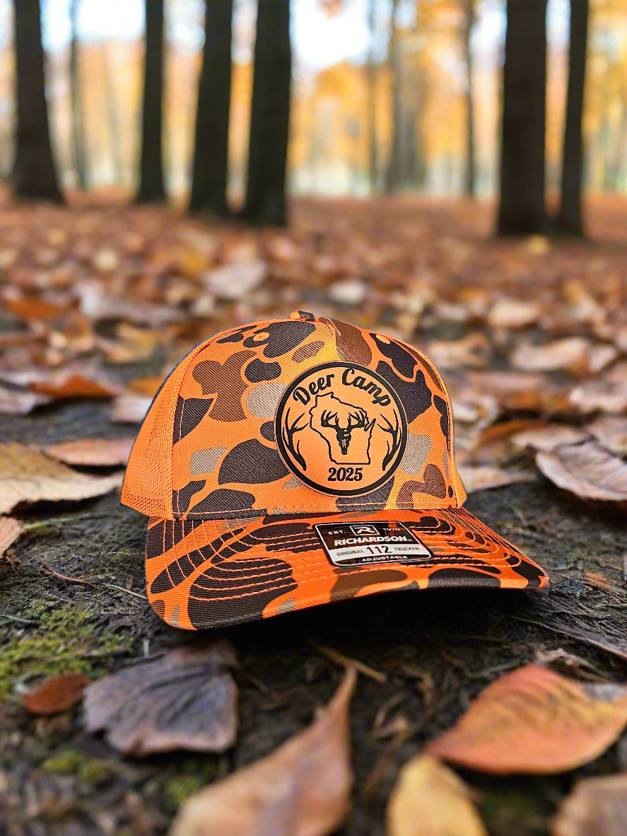 Orange and black baseball cap with a logo on a textured surface