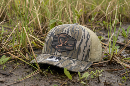 Camouflage cap on the ground in a grassy, outdoor setting