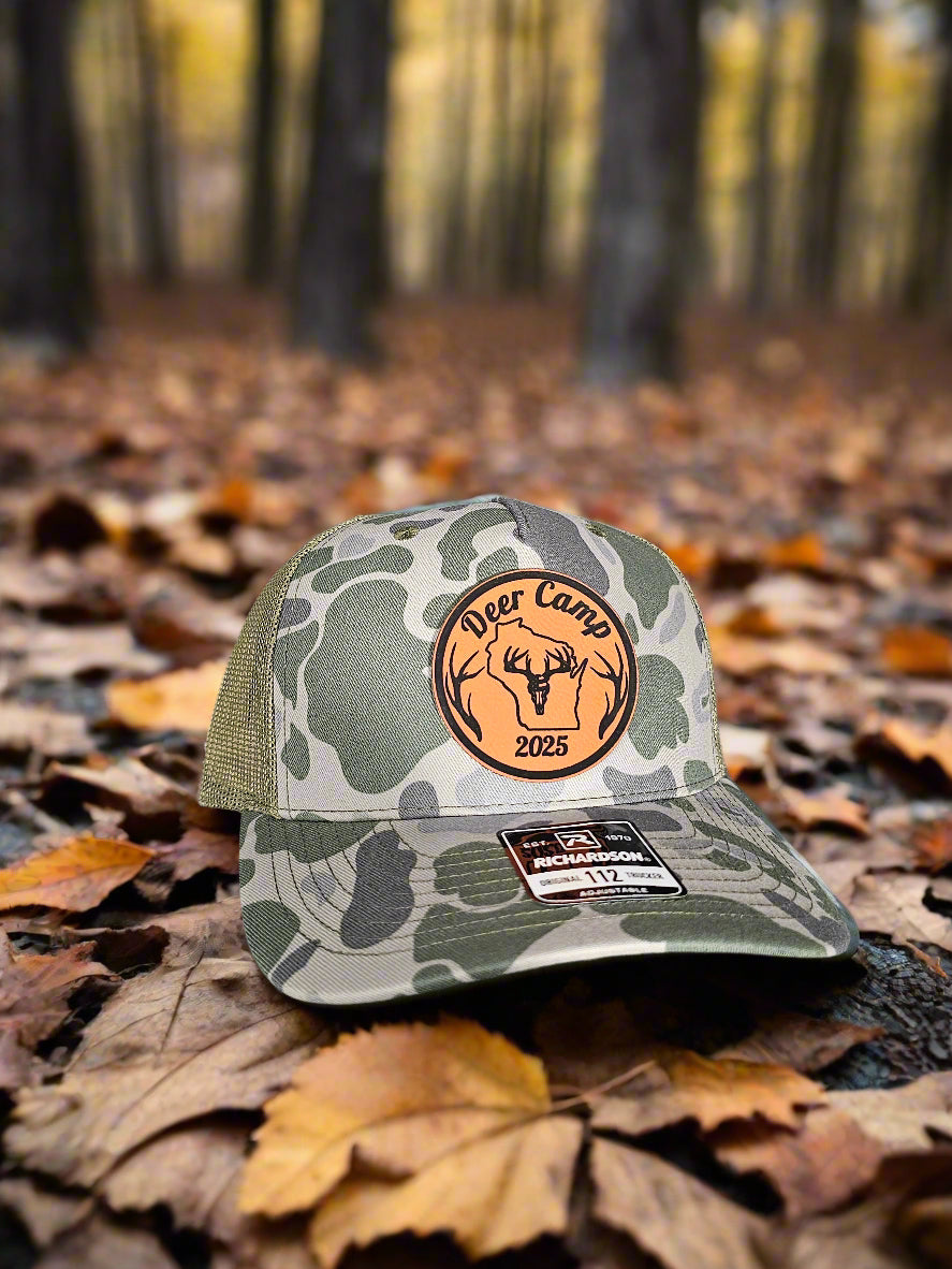 Camouflage-patterned cap with brand logo on a textured surface