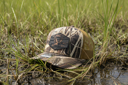 Camouflage cap on a gray surface with a white background