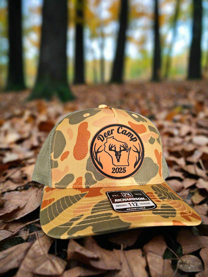 Camouflage-patterned cap with a logo and text on a textured surface